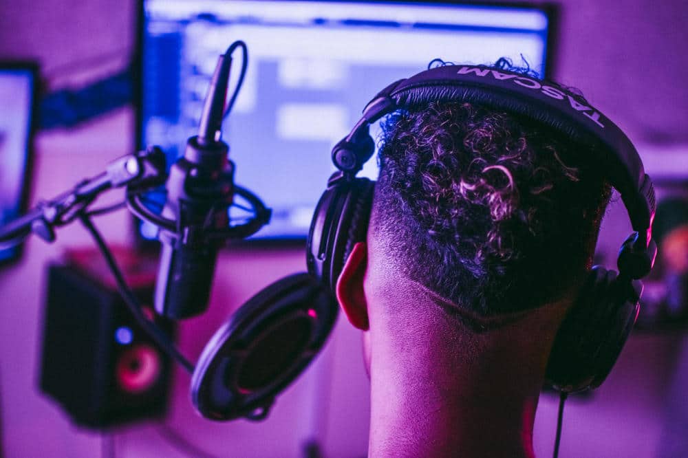 man sits with headphones on a microphone at the pc