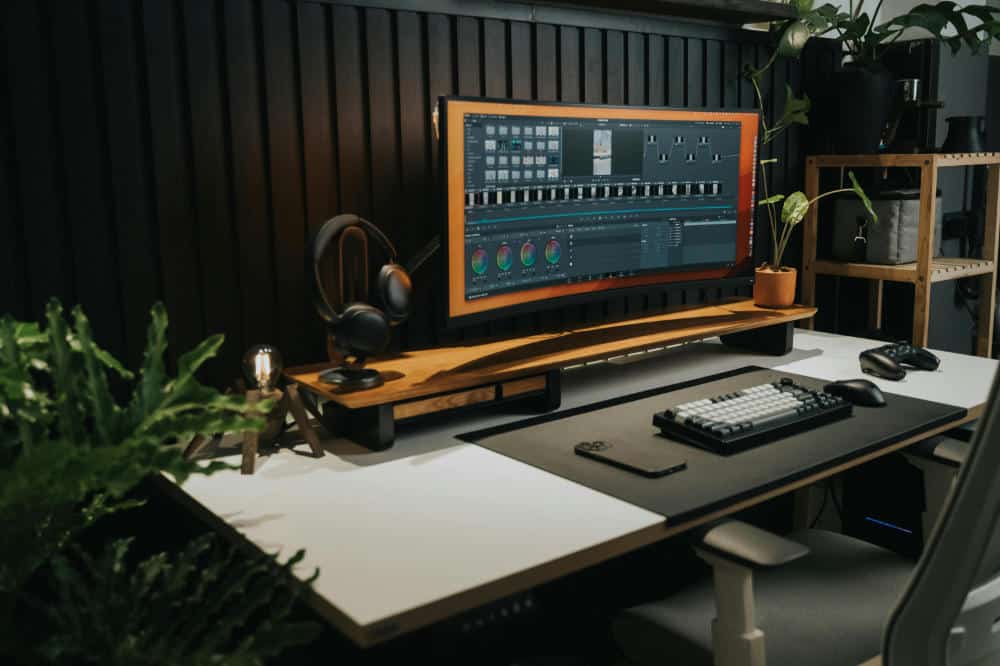 office desk with keyboard and curved monitor